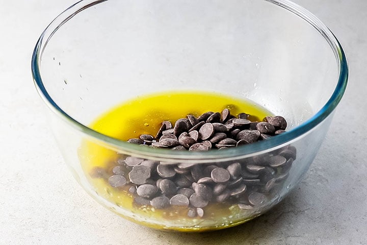 Chocolate chips added to melted butter in a glass bowl
