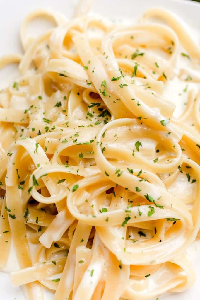 Alfredo pasta dinner with creamy white sauce and herbs