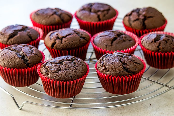 Chocolate cupcakes cooling on a cooling rack.