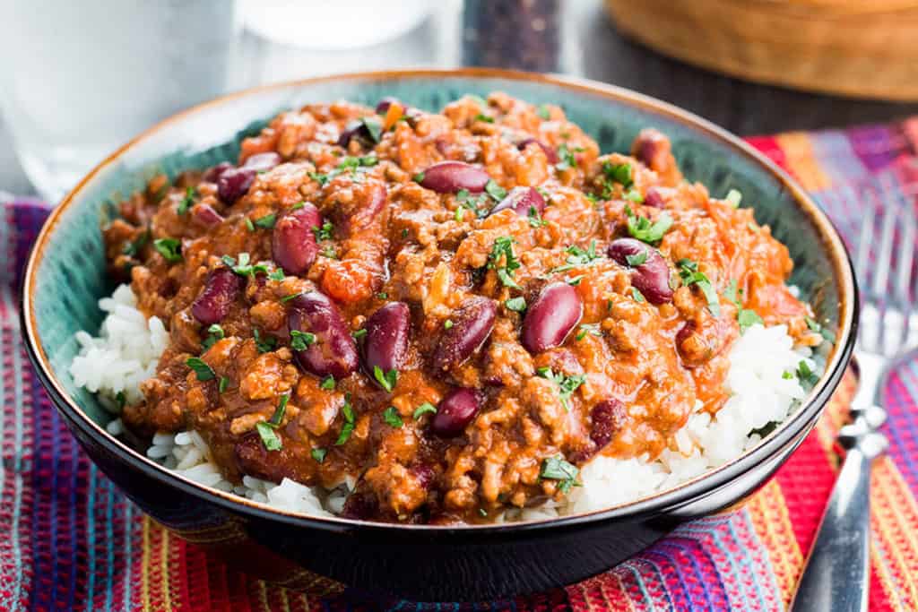 A bowl of food on a table, with Chili con carne and Chili powder