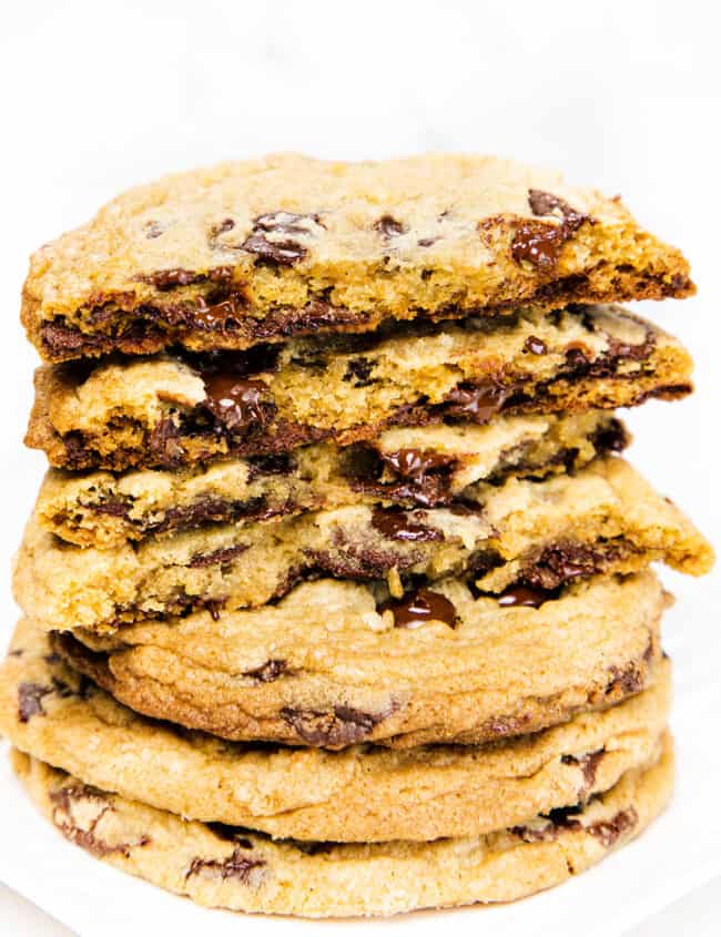 a pile of chocolate chip cookies broken open to expose the inside of the cookies