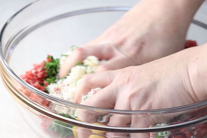 Meatball mixture being hand mixed 