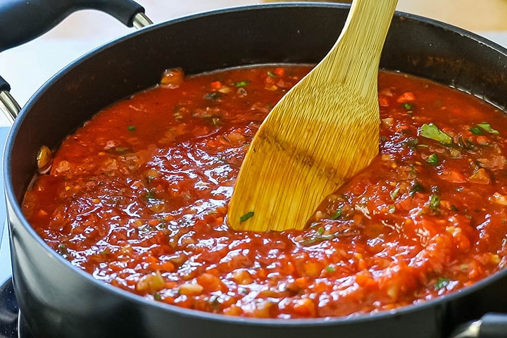 The sauce being stirred in the pot