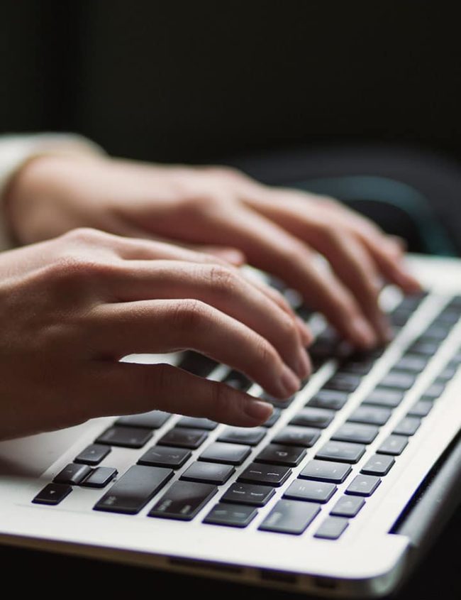 Hands typing on a keyboard