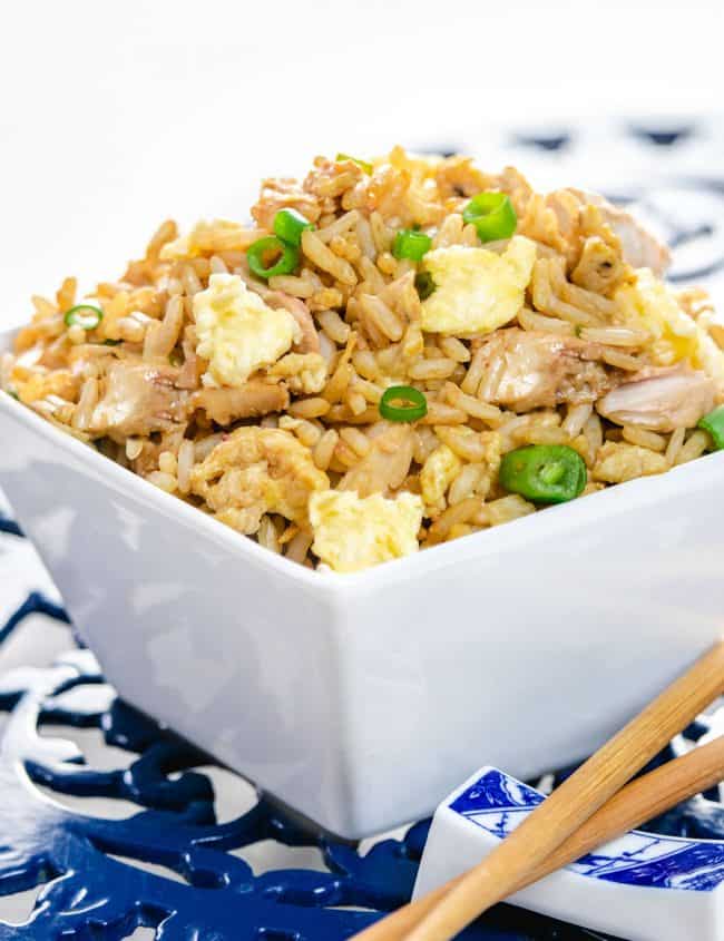 A bowl of fried rice with chop sticks next to it