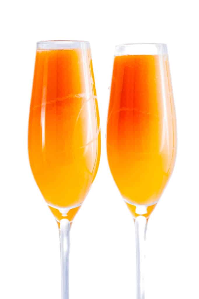 two mimosas in long stem glasses