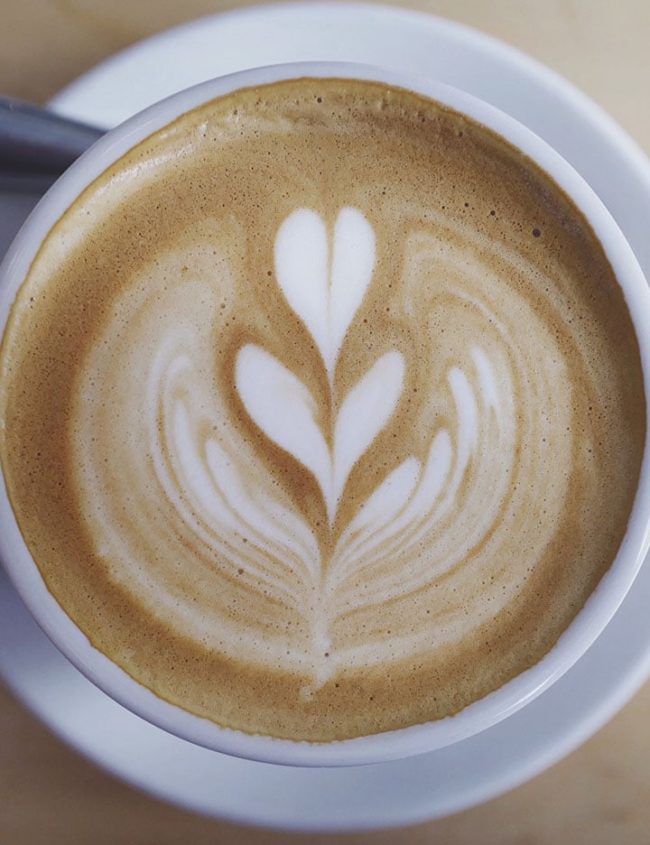 A latte with a flower shape in the frothed milk