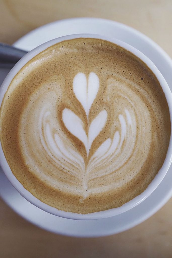 A latte with a flower shape in the frothed milk