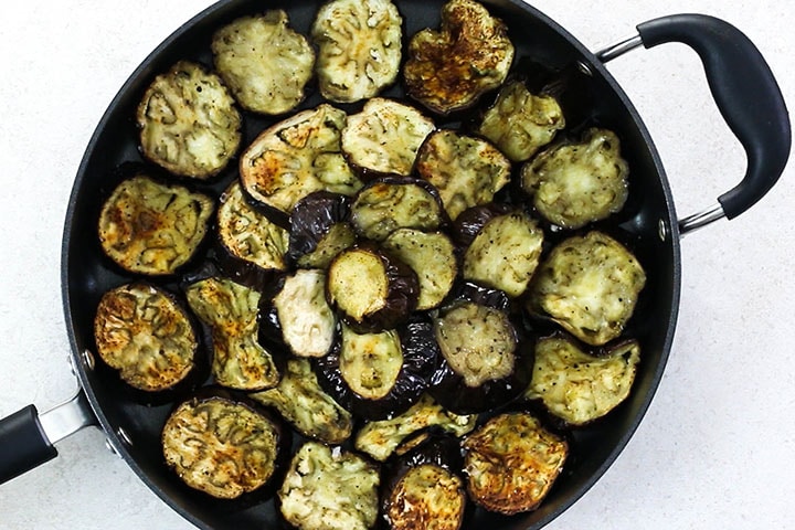 The roasted eggplant arranged in a baking pan