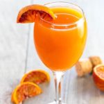 The Perfect Mimosa with a wedge of blood orange on the glass