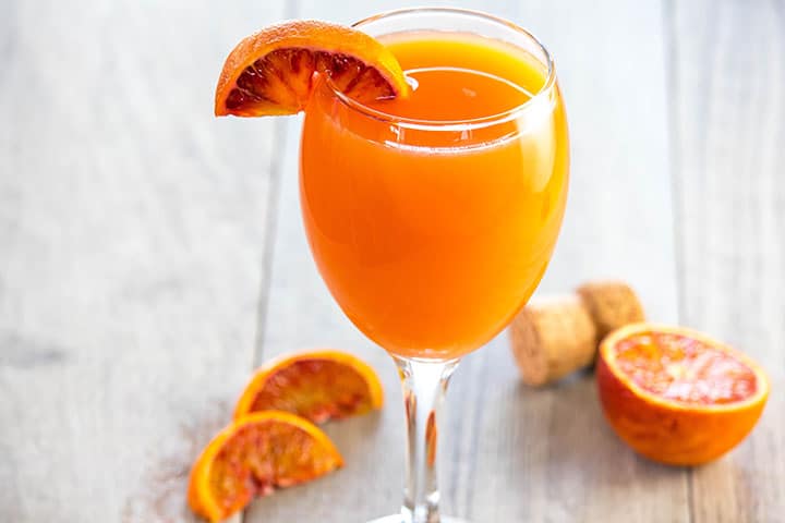 The Perfect Mimosa with a wedge of blood orange on the glass