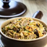 easy mushroom rice pilaf in a serving dish with the lid behind it