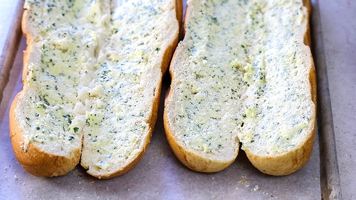 The garlic butter and grated cheese spread across the bread