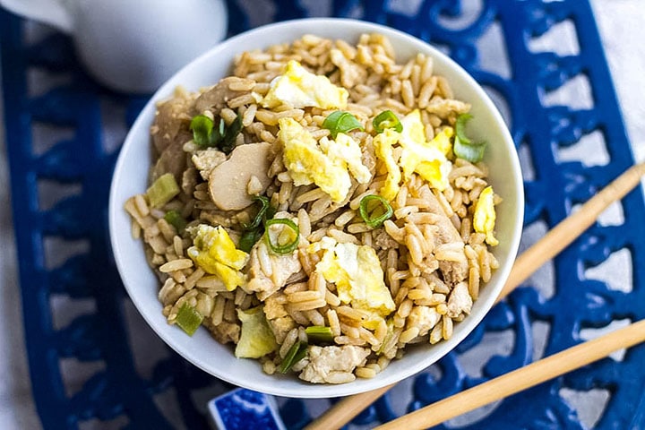 A bowl of low fat chicken fried rice with chopsticks next to it