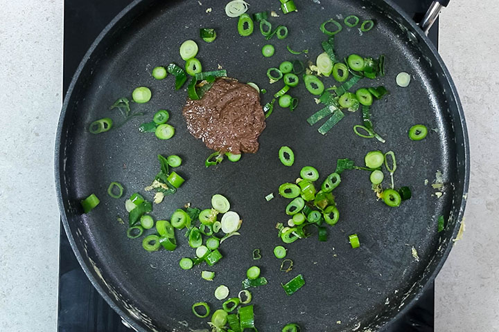 Spring onions and anchovy paste in the pan