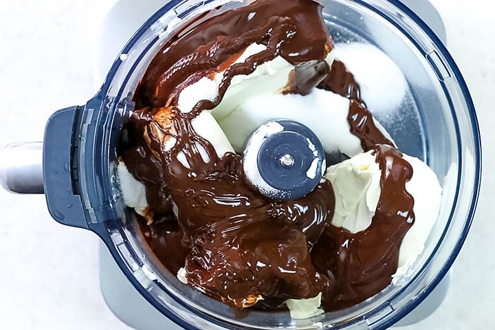 The melted chocolate added to the bowl with the cream cheese mixture