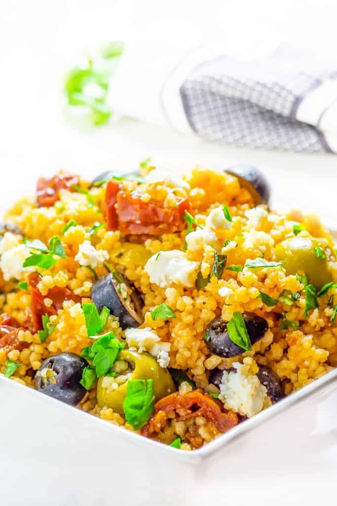 a bowl of couscous with vegetables and olives