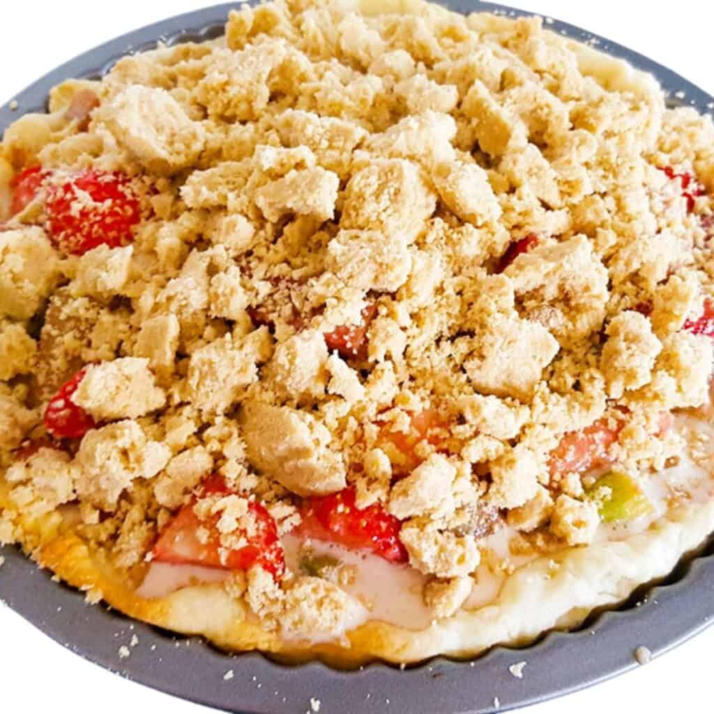 Rhubarb and Strawberry Crumb Pie filled and topped with the crumb topping ready to bake