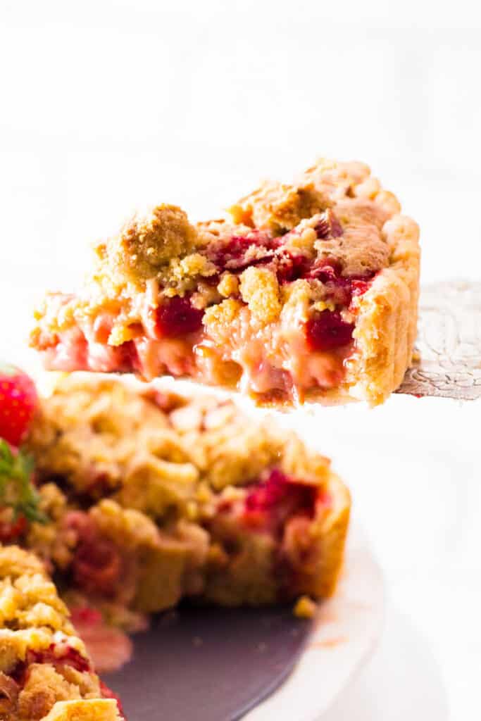 a slice of Strawberry Rhubarb Pie being served with a pie cutter