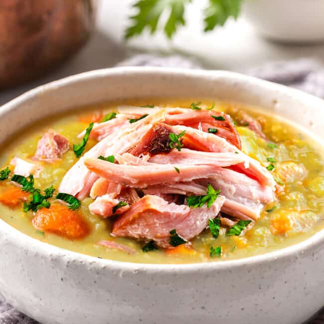 a bowl of split pea soup topped with shredded ham meat
