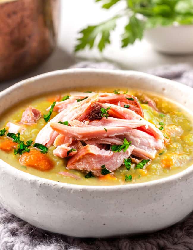 a bowl of split pea soup topped with shredded ham meat