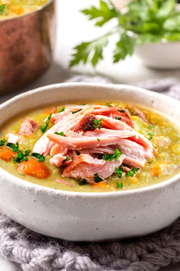 a bowl of split pea soup topped with shredded ham meat