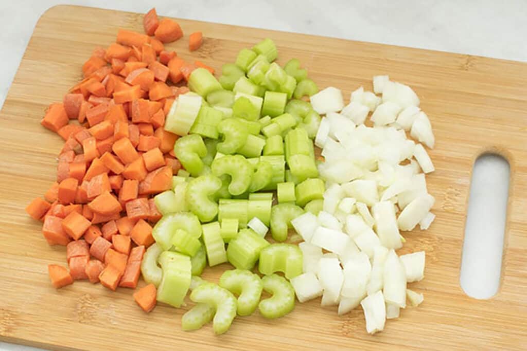 Chopped Onion, Celery, and Carrots on a Cutting Board