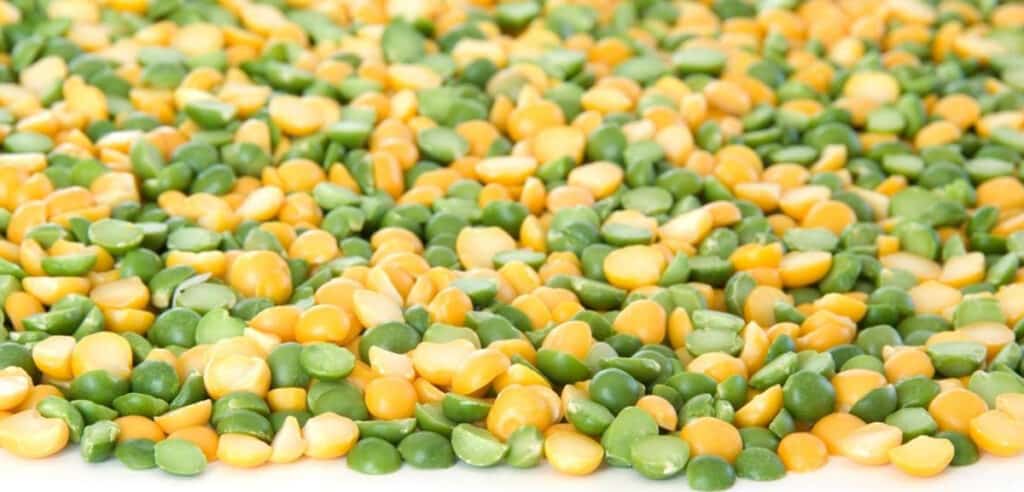 green and yellow split peas scattered on a white surface