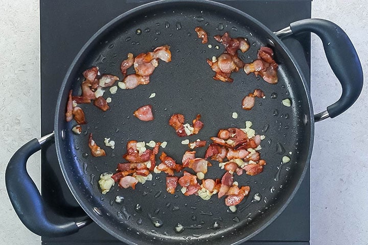 Chopped bacon cooking with garlic in a pan