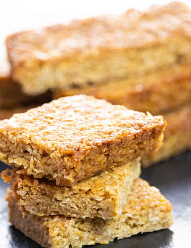 Classic British Flapjacks stacked on top of each other with more in the background