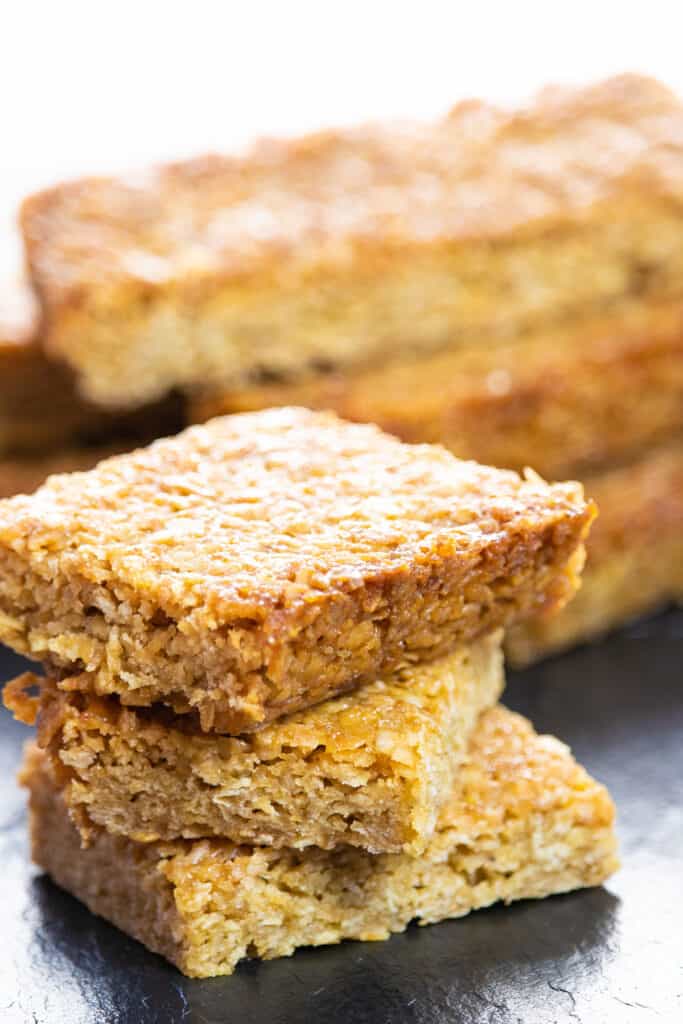 Classic British Flapjacks stacked on top of each other with more in the background