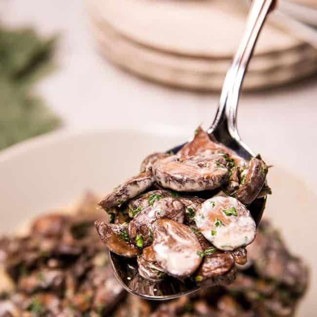 Creamy Garlic Mushrooms being served with a serving spoon