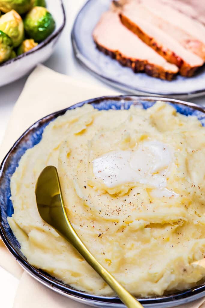 A big bowl of mashed potatoes with butter melting on top.