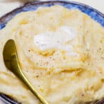 a bowl of freshly made mashed potatoes topped with butter.