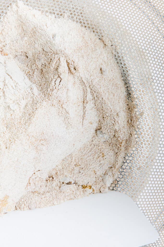 the dry ingredients of the Crumb Coffee Cake topping being sifted into a bowl 