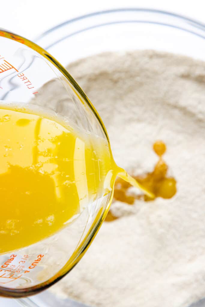 The butter being poured into the dry ingredients of the Crumb Coffee Cake