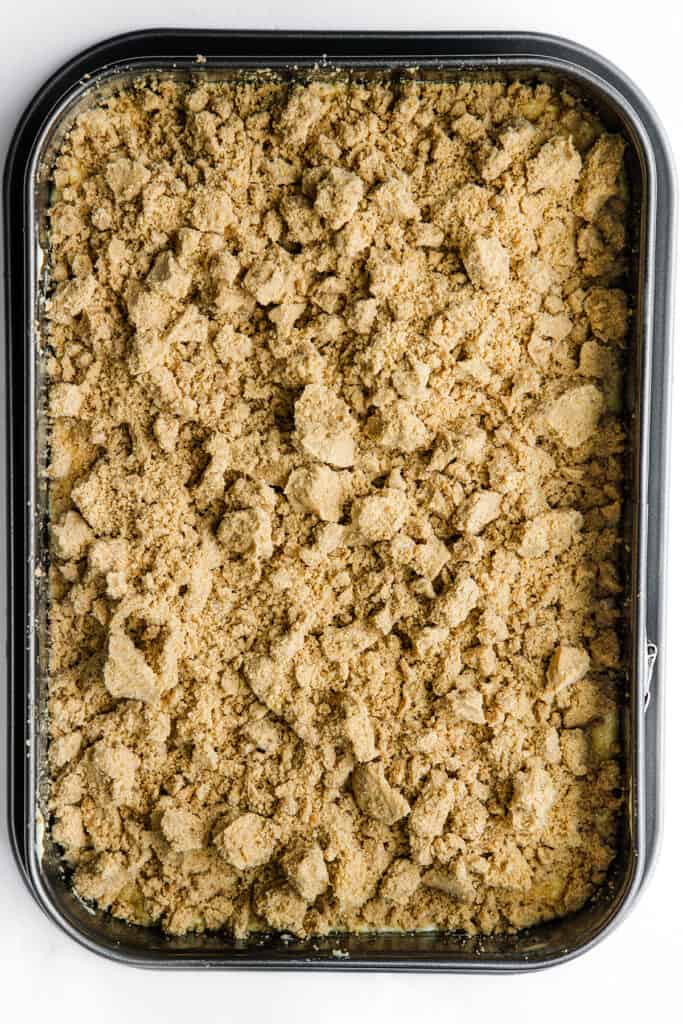 the cake batter covered in the crumb topping in the pan
