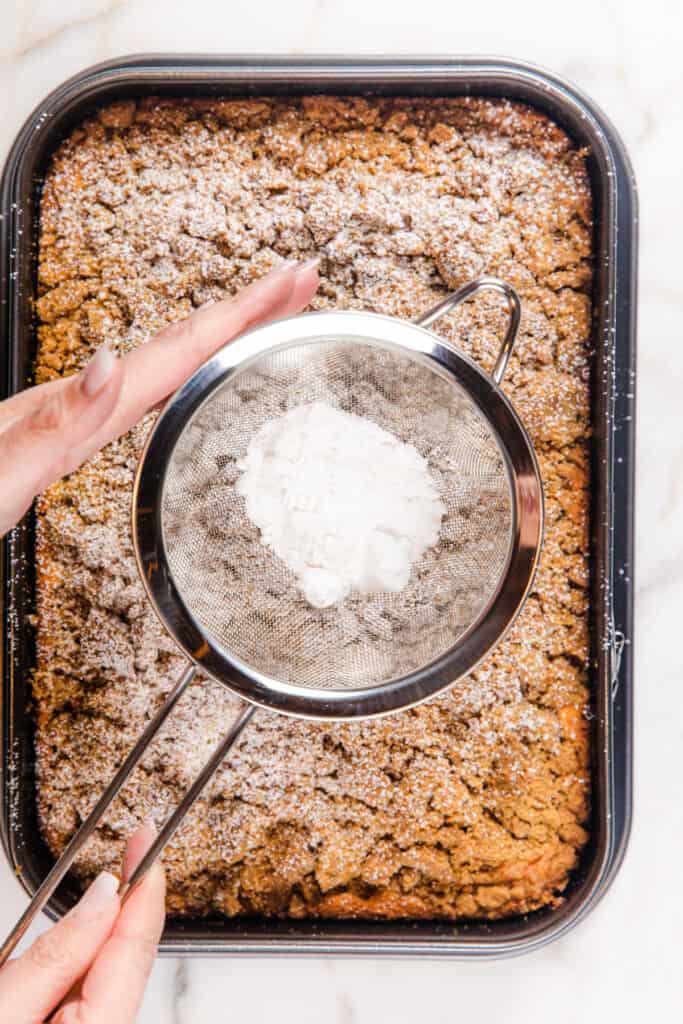 the Crumb Coffee Cake being dusted with powdered sugar