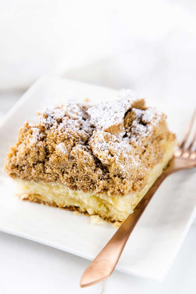 a slice of Crumb Coffee Cake on a white plate with a fork