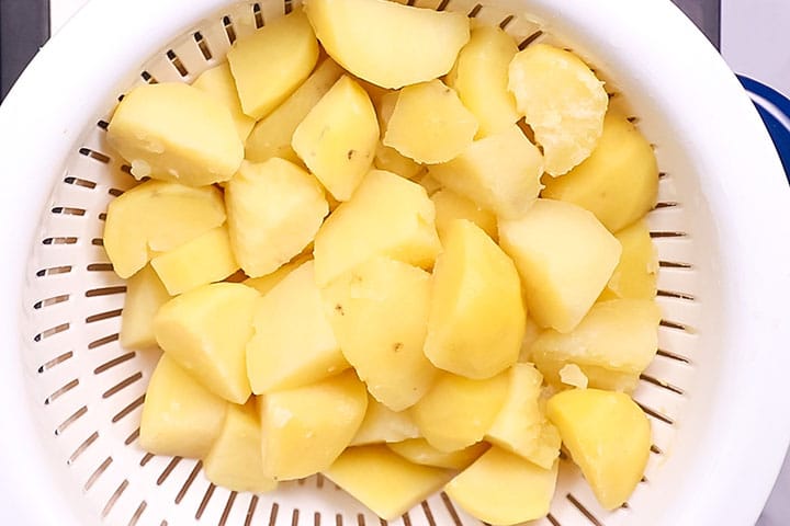 Drained potatoes sitting in a strainer 