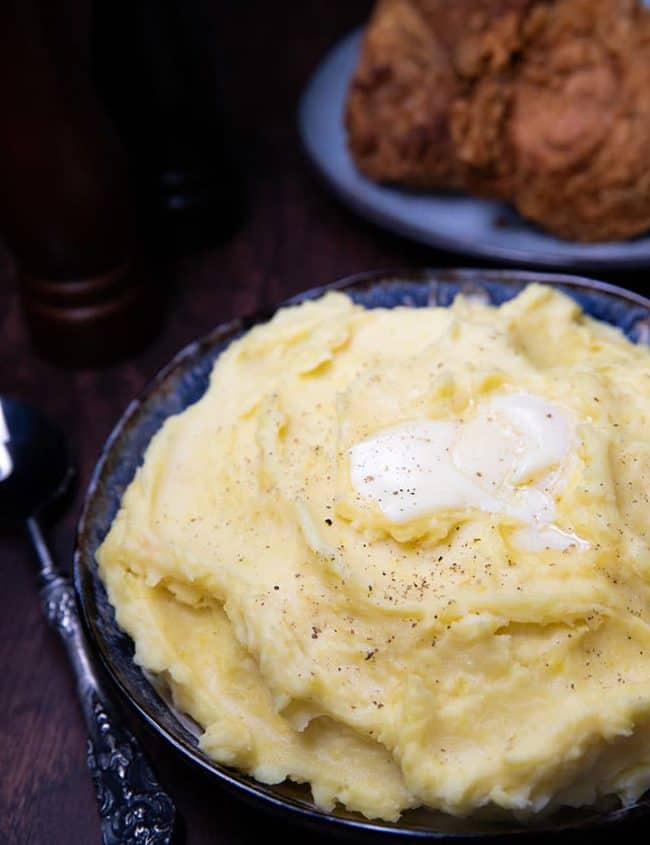 A big bowl of mashed potatoes with butter melting on top
