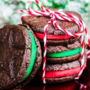 Una pila de galletas Oreo navideñas envueltas con un lazo con una inclinada contra ellas