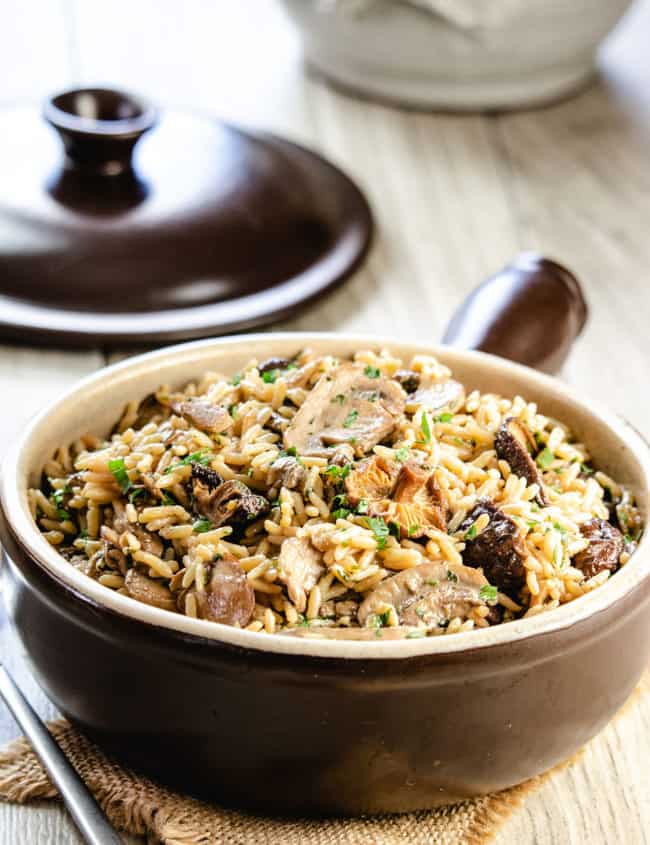 easy mushroom rice pilaf in a serving dish with the lid behind it
