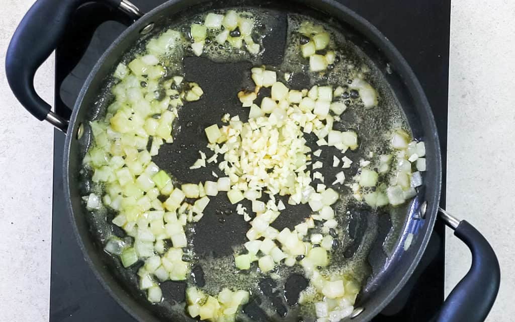 The garlic added to the pan with the onions
