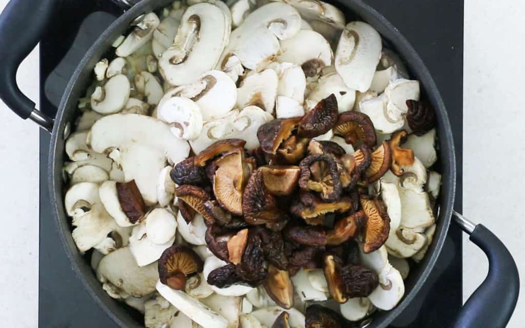 The mushrooms added to the pan with the onions and garlic