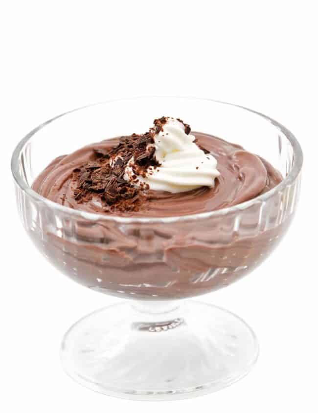 Homemade Dark Chocolate Pudding in a dessert glass topped with chocolate shavings and a scoop missing from one glass