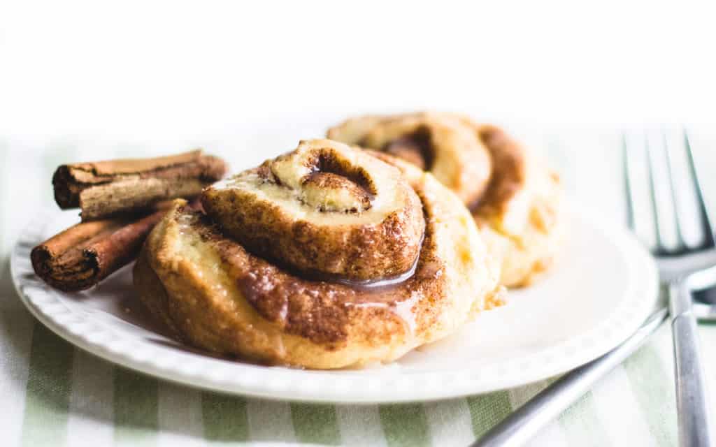 Cinnamon Swirl Scones on a plate with cinnamon sticks