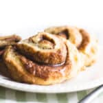 Cinnamon Swirl Scones on a plate with cinnamon sticks