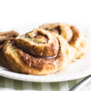 Cinnamon Swirl Scones on a plate with cinnamon sticks