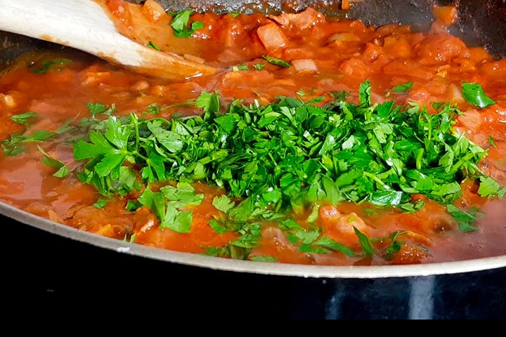 the parsely added to the pan with the sauce.